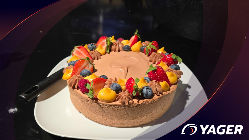 A round chocolate cake decorated with fresh strawberries, blueberries and raspberries